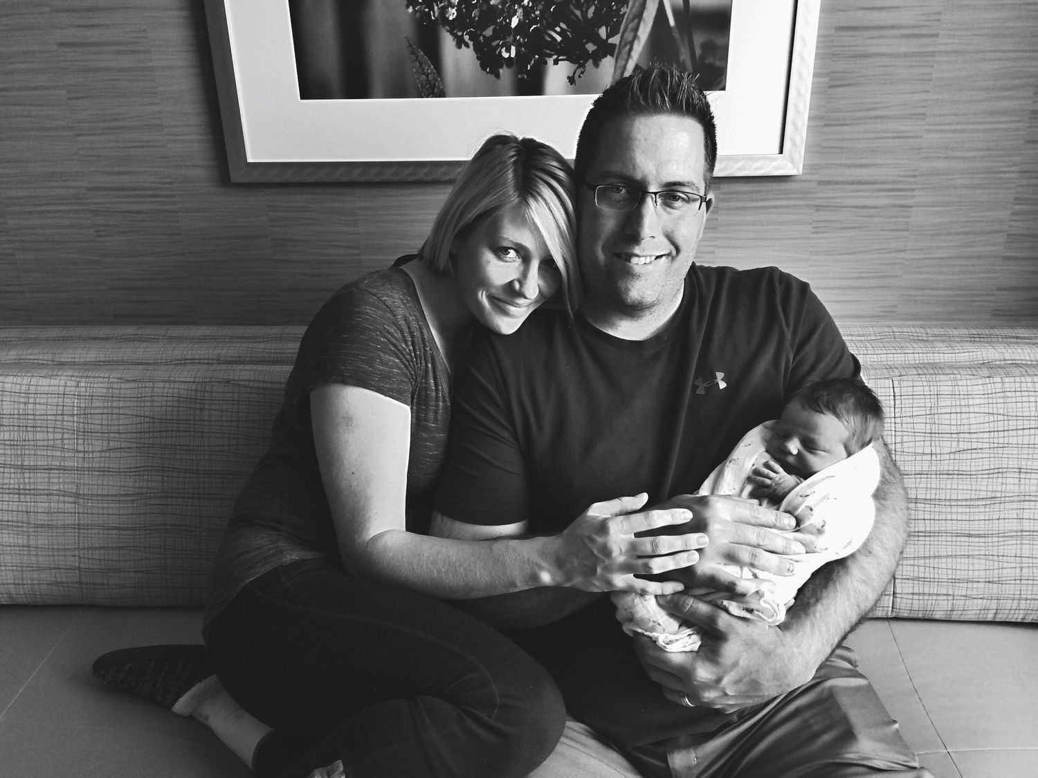Black and white family portrait sequence showing tender moments on a couch.