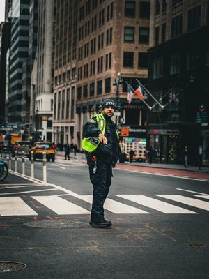 Traffic officer directing vehicles at an intersection in an urban setting.