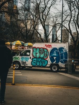 Colorful graffiti art spans across a long concrete wall in an urban setting.