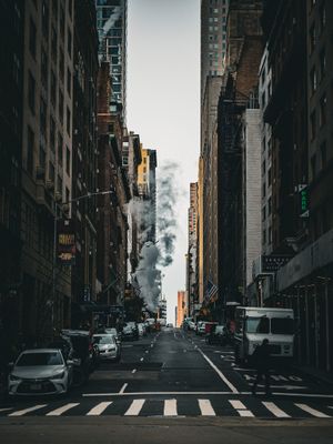 Dark city street with tall buildings creating a canyon-like perspective in New York.