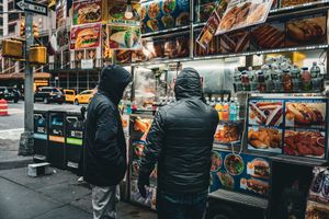 Street vendors and food carts lined up along a busy city sidewalk.
