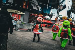 Street performers in bright costumes entertaining pedestrians in an urban setting.
