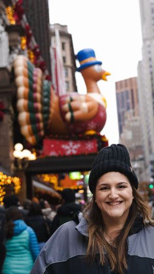 Holiday display features giant turkey balloon against city buildings.