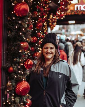 Christmas decorations and twinkling lights create a festive atmosphere at an outdoor shopping area.