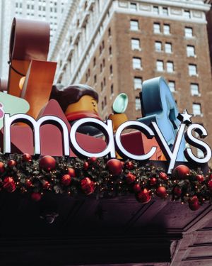 Macy's department store sign with festive red ornaments and holiday decorations.
