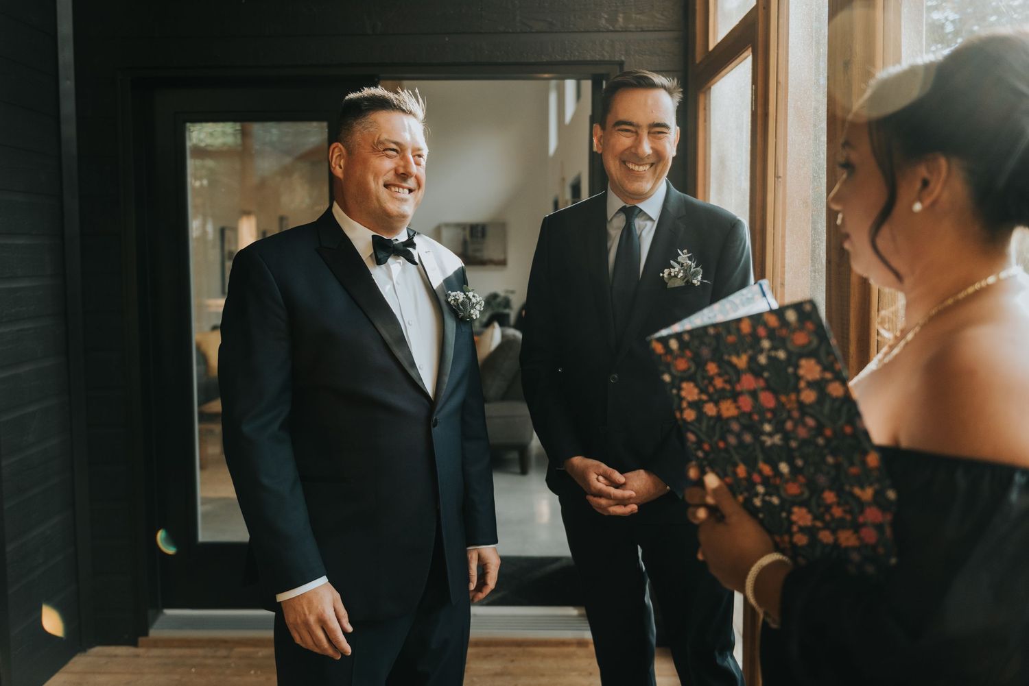 Joyful reaction during wedding preparations inside a warmly lit indoor venue with formal attire.