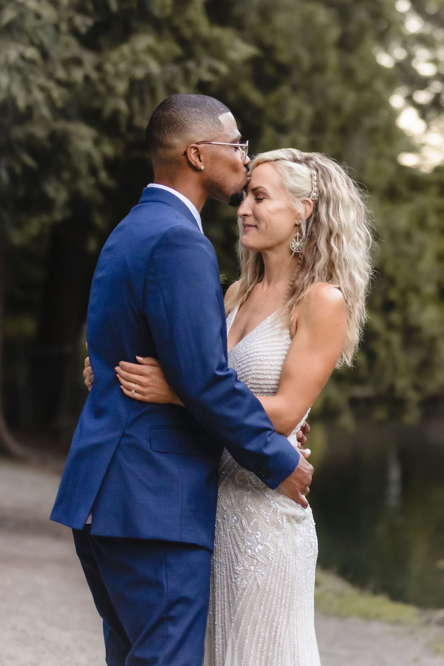 Intimate moment between newlyweds sharing a tender embrace during their outdoor wedding photoshoot.