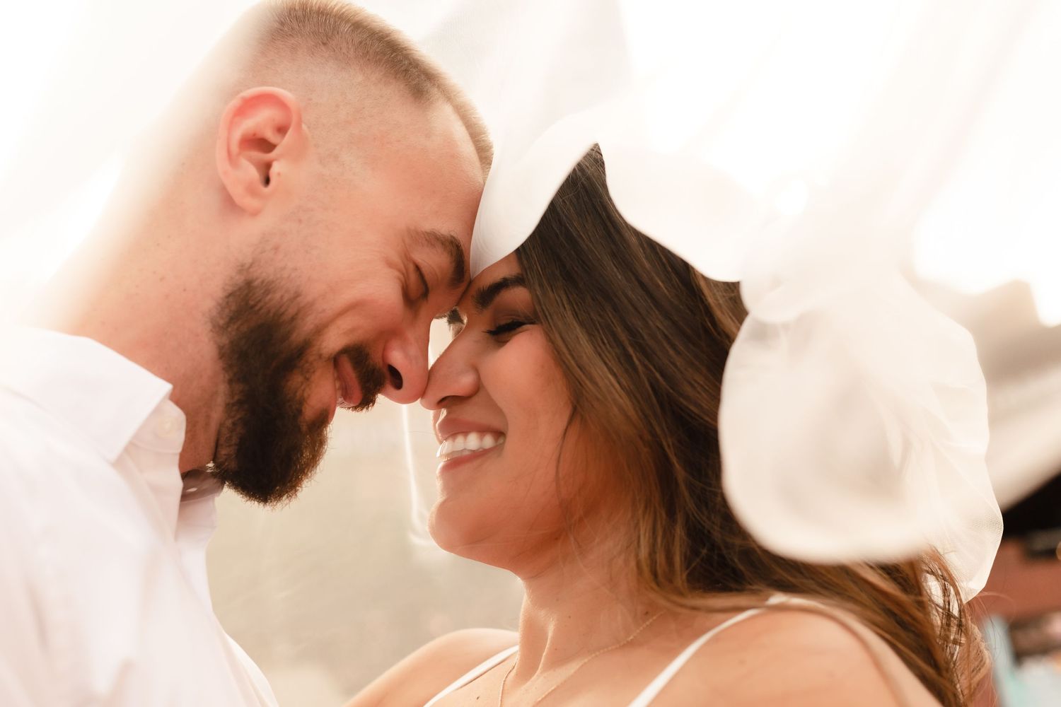 An intimate close-up moment between newlyweds with warm lighting and genuine smiles.