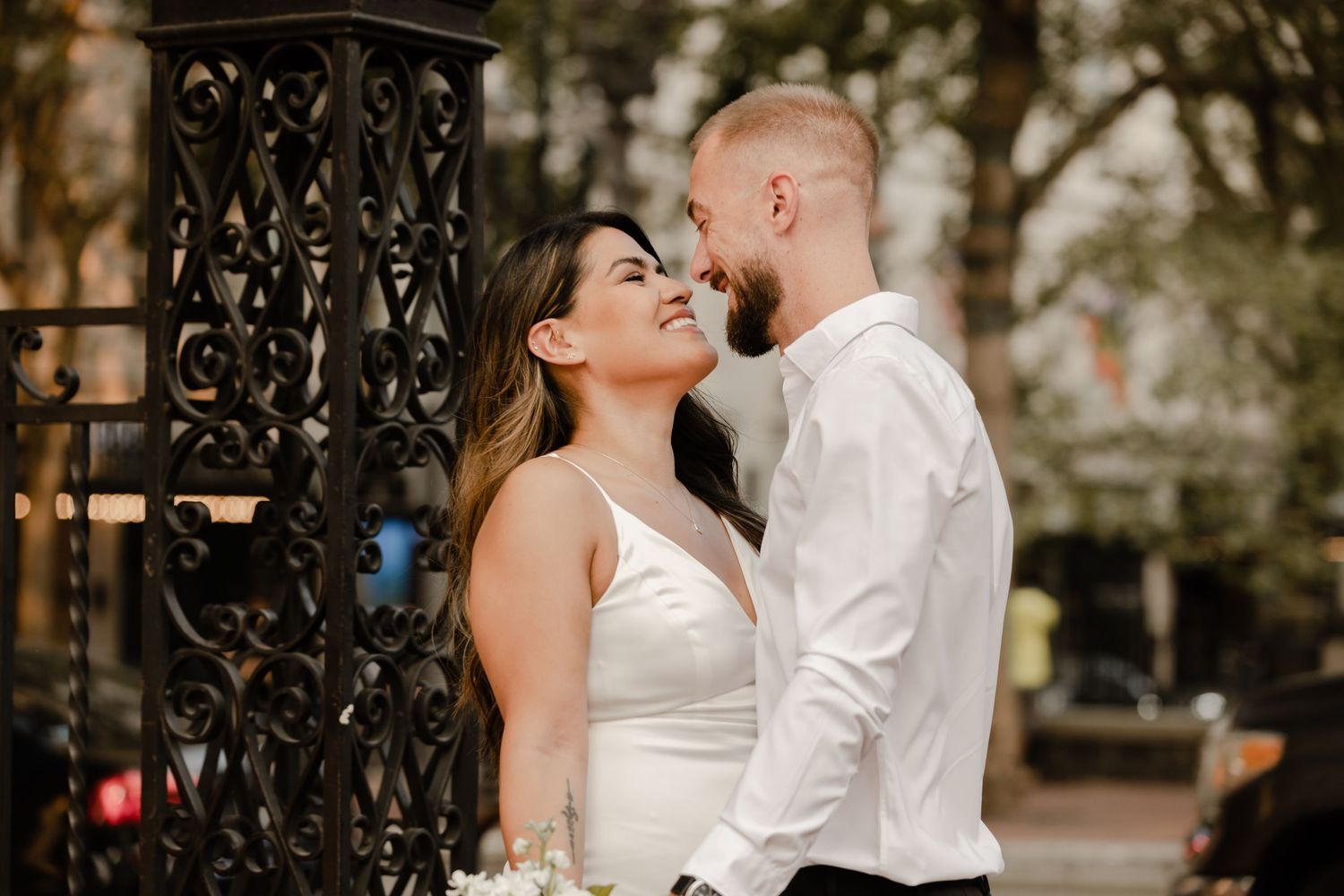 A romantic outdoor portrait by decorative iron gates with natural lighting.