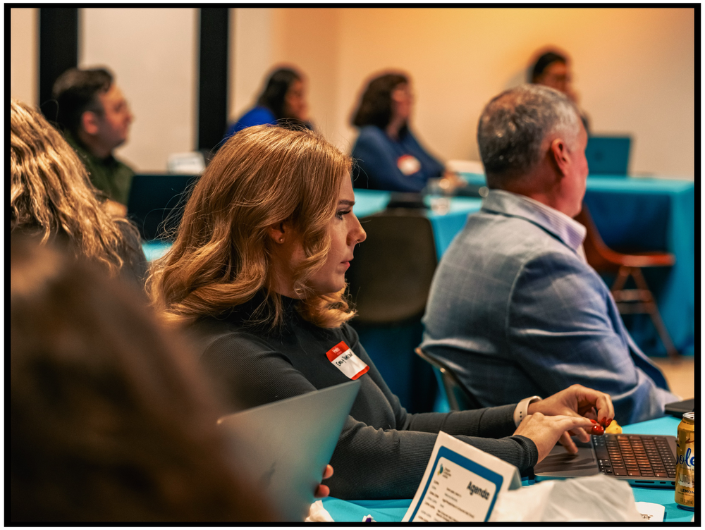 Conference attendees taking notes during a business presentation. Portland event photographer