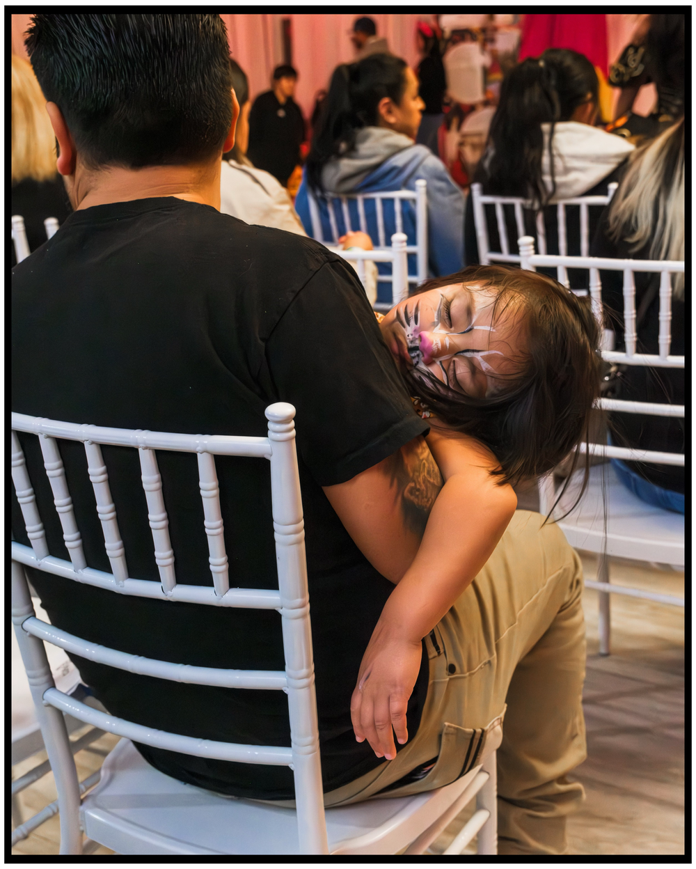 Young child sleeping peacefully on parent's shoulder during celebration event. Portland event photographer