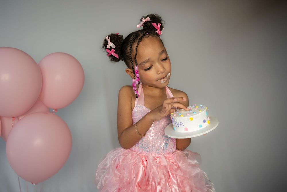 Pink birthday celebration with balloons and cake featuring a special moment.