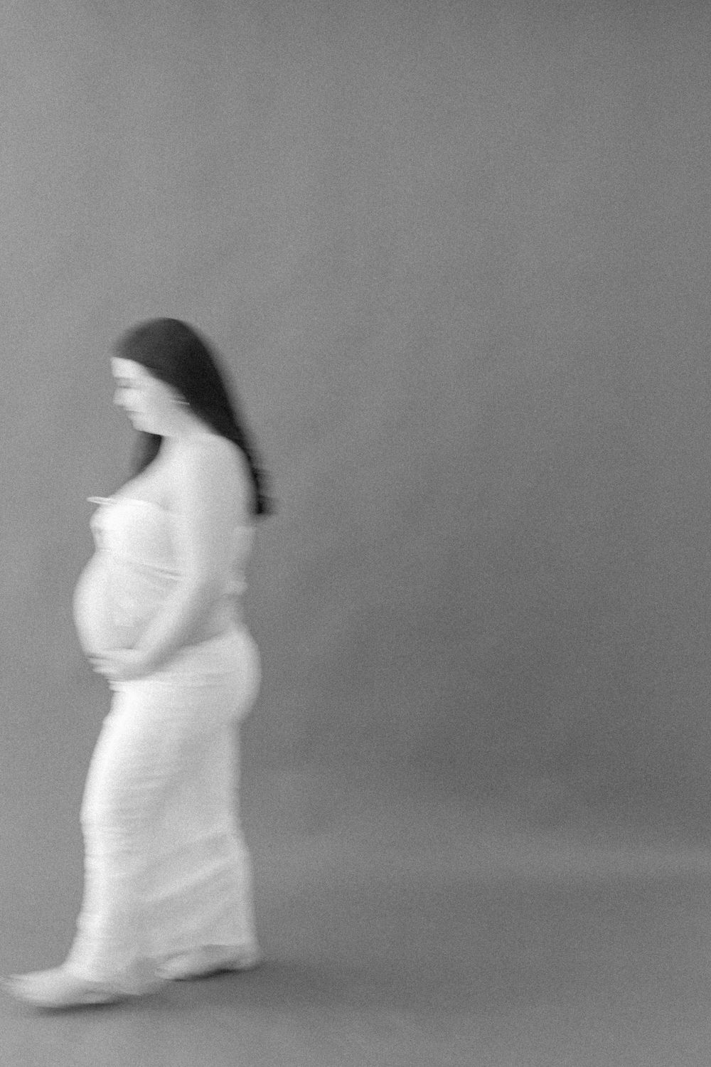 Artistic black and white maternity silhouette in motion.