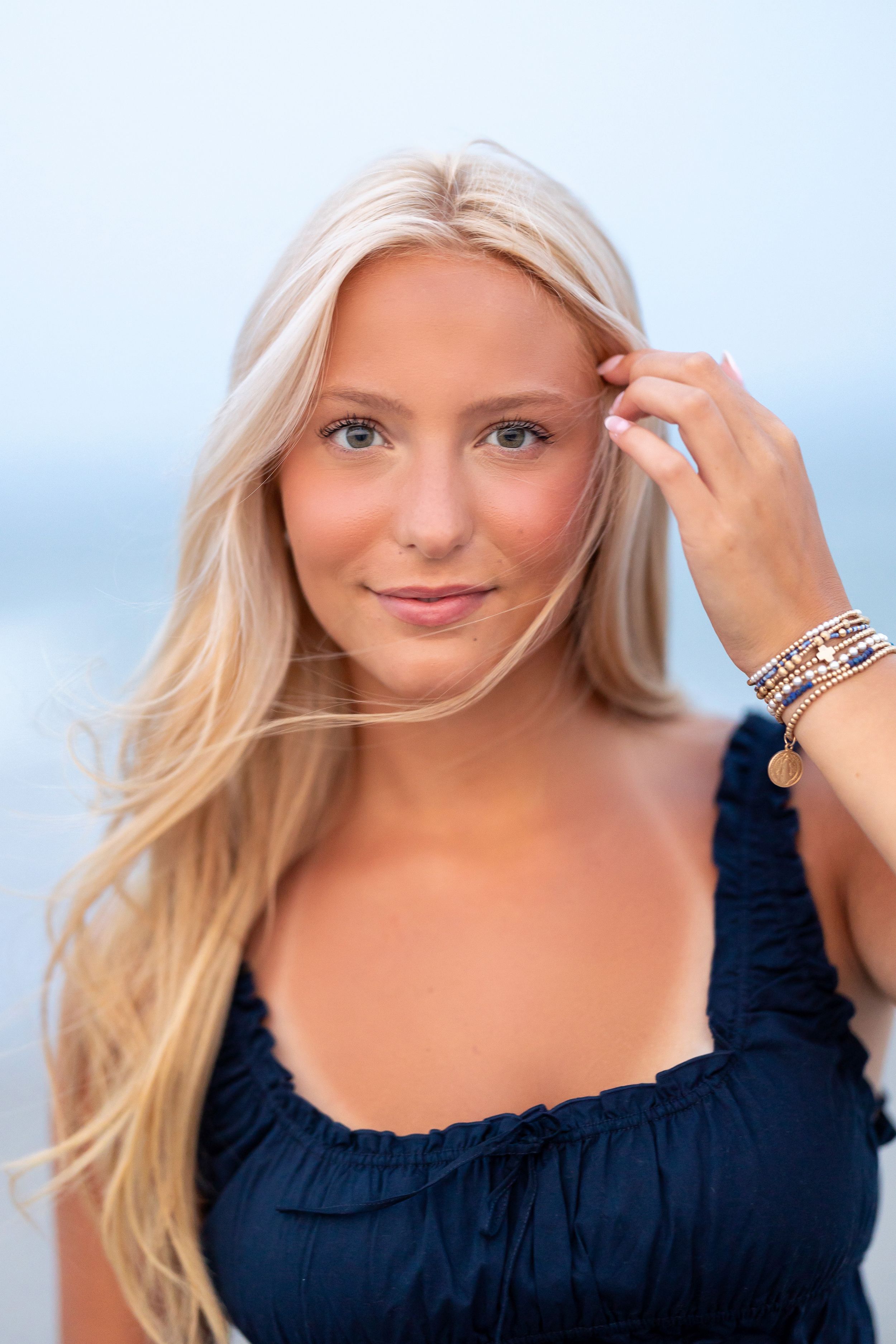 High school senior portrait at sunset at Hampton Beach, NH with sand and water