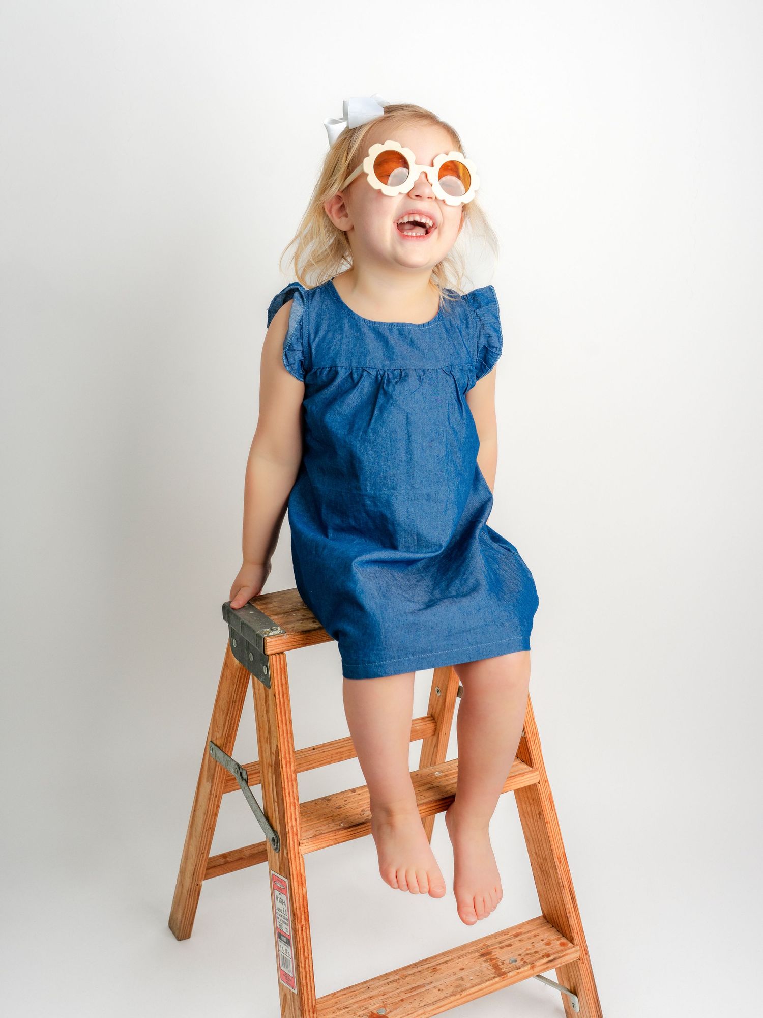 Picture of a little girl on ladder with flower glasses in Dandridge TN photographer's studio for children photo session.
