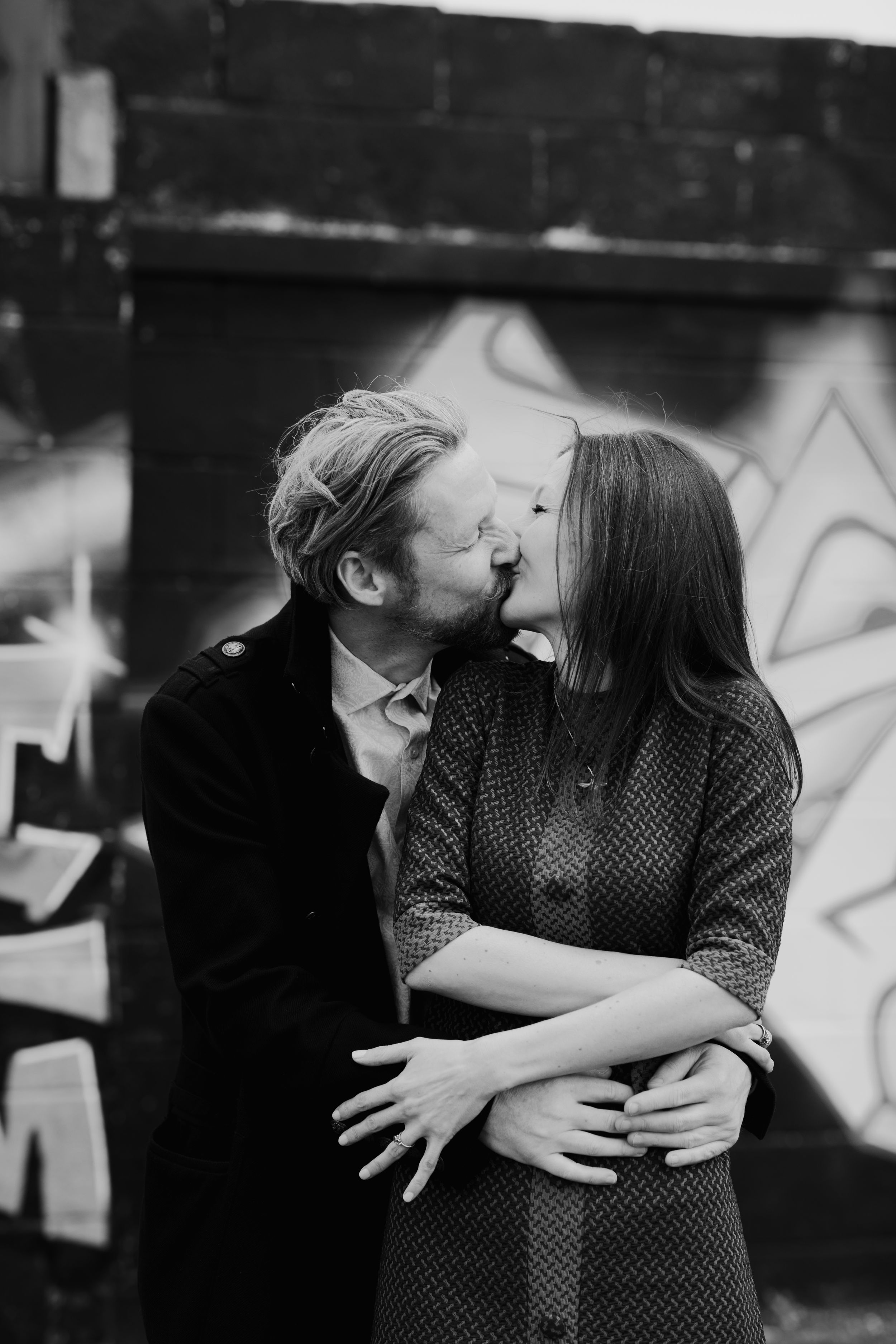 An intimate black and white moment between a couple sharing a tender kiss.