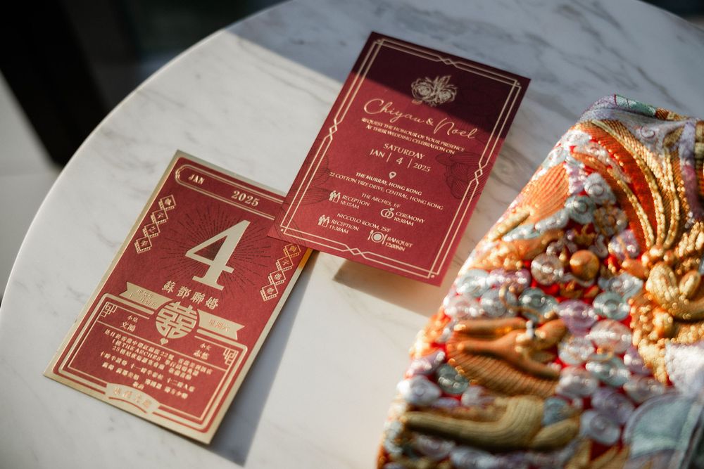 Chinese wedding table number card and invitation on marble table with traditional red kua garment.