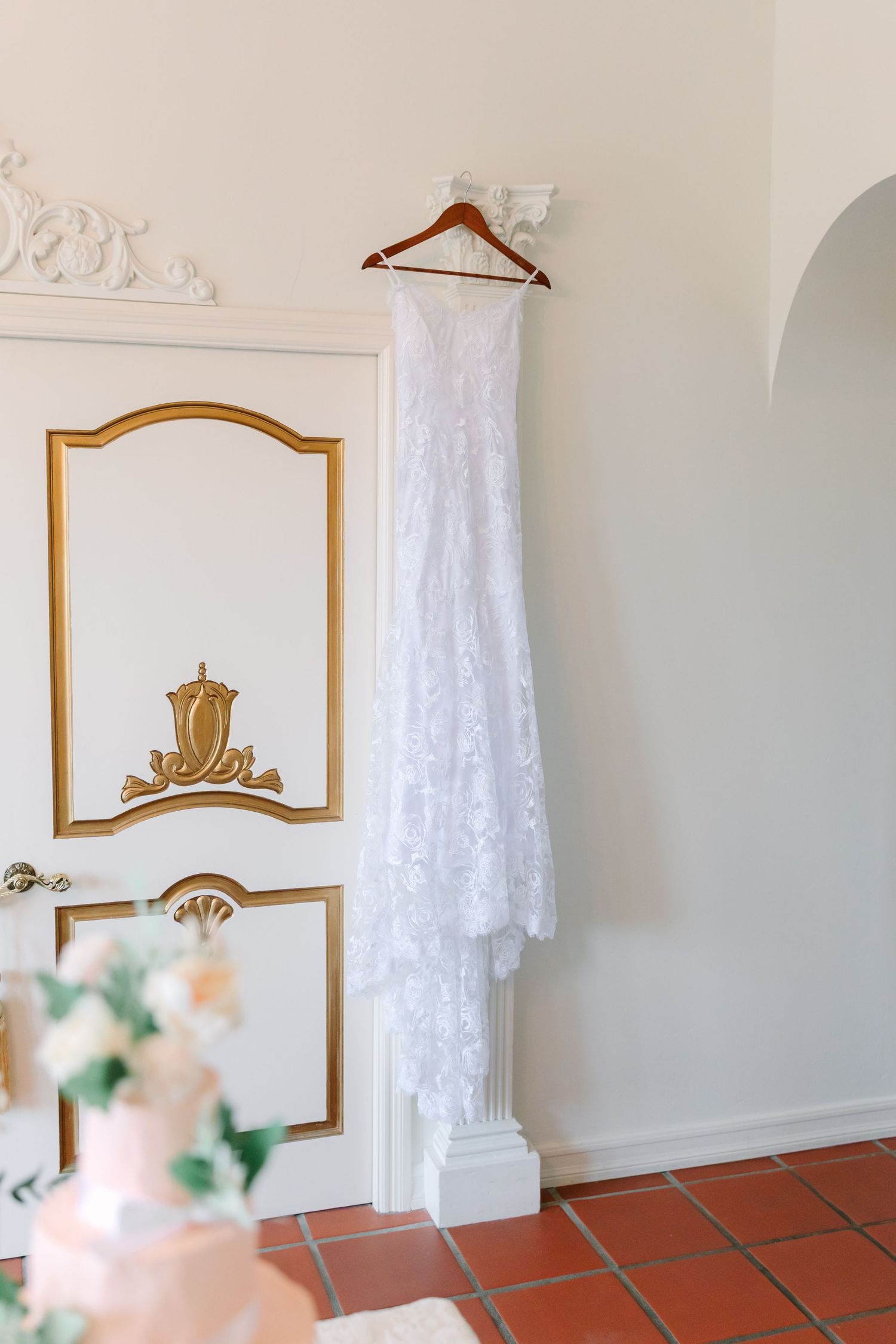 Elegant white dressing room interior with ornate gold-framed mirrors and lace curtains creating a vintage aesthetic.