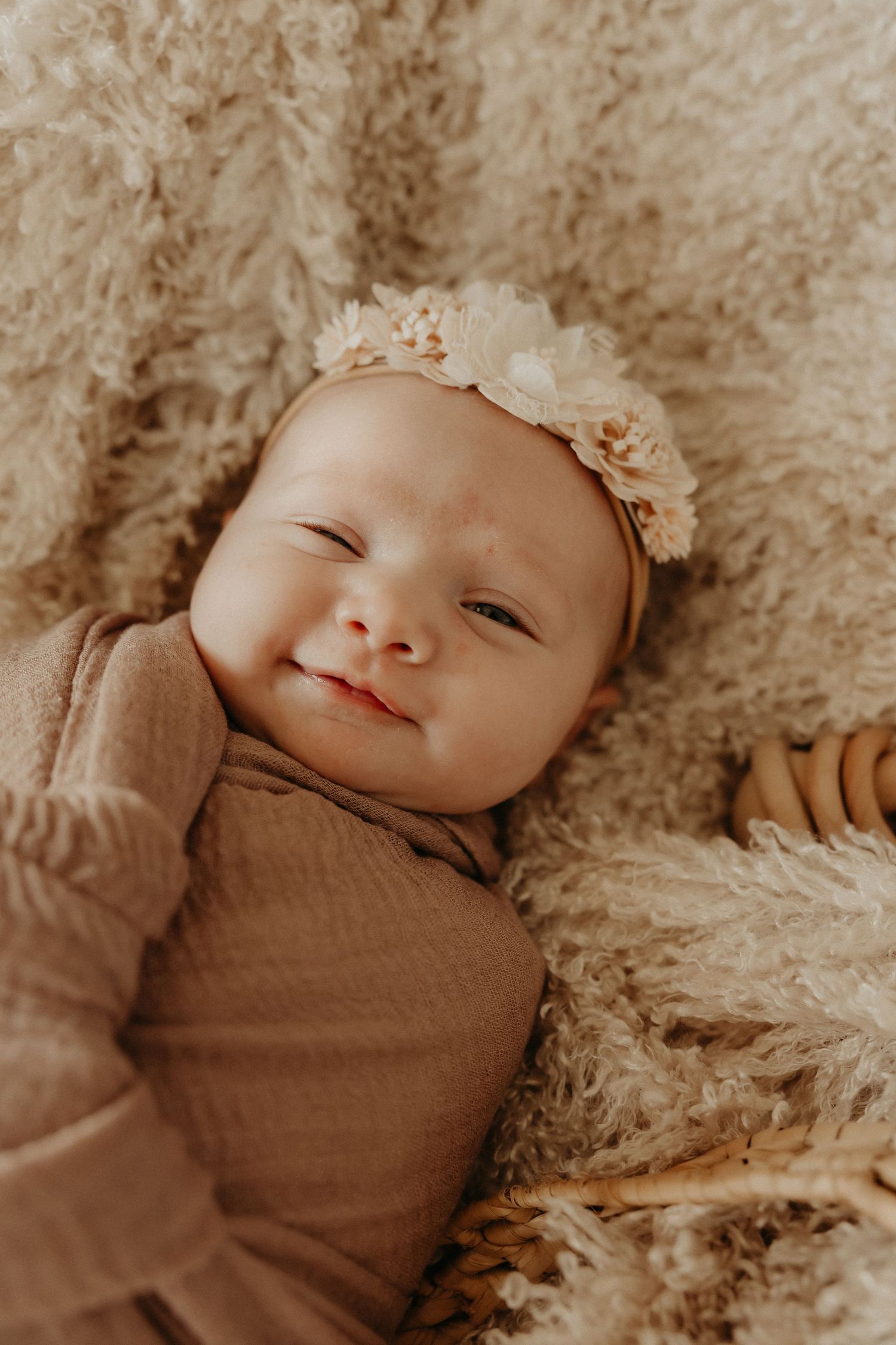 Newborn baby sleeping peacefully on a soft blanket, captured in a cozy indoor photoshoot.