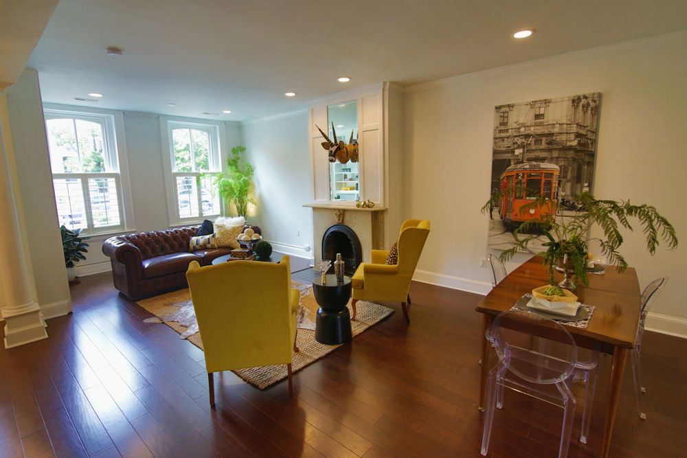 Contemporary living room with leather sofa, yellow chairs and hardwood floors.