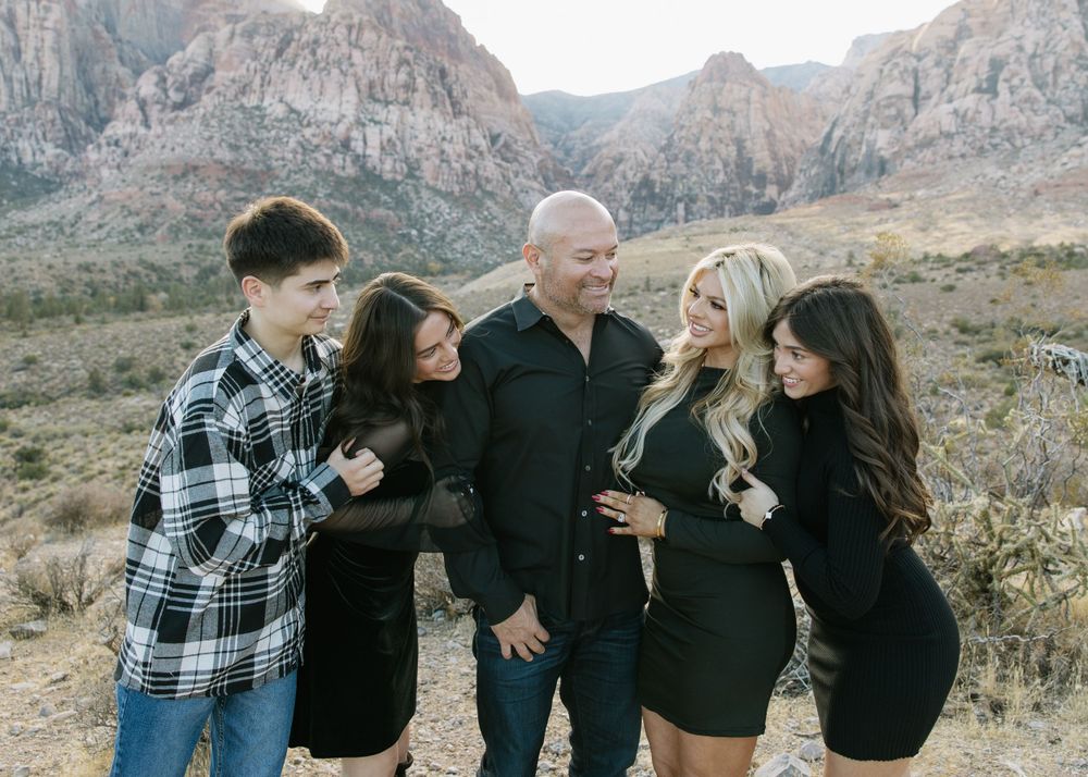 Family gathering in casual attire against a dramatic desert mountain backdrop.