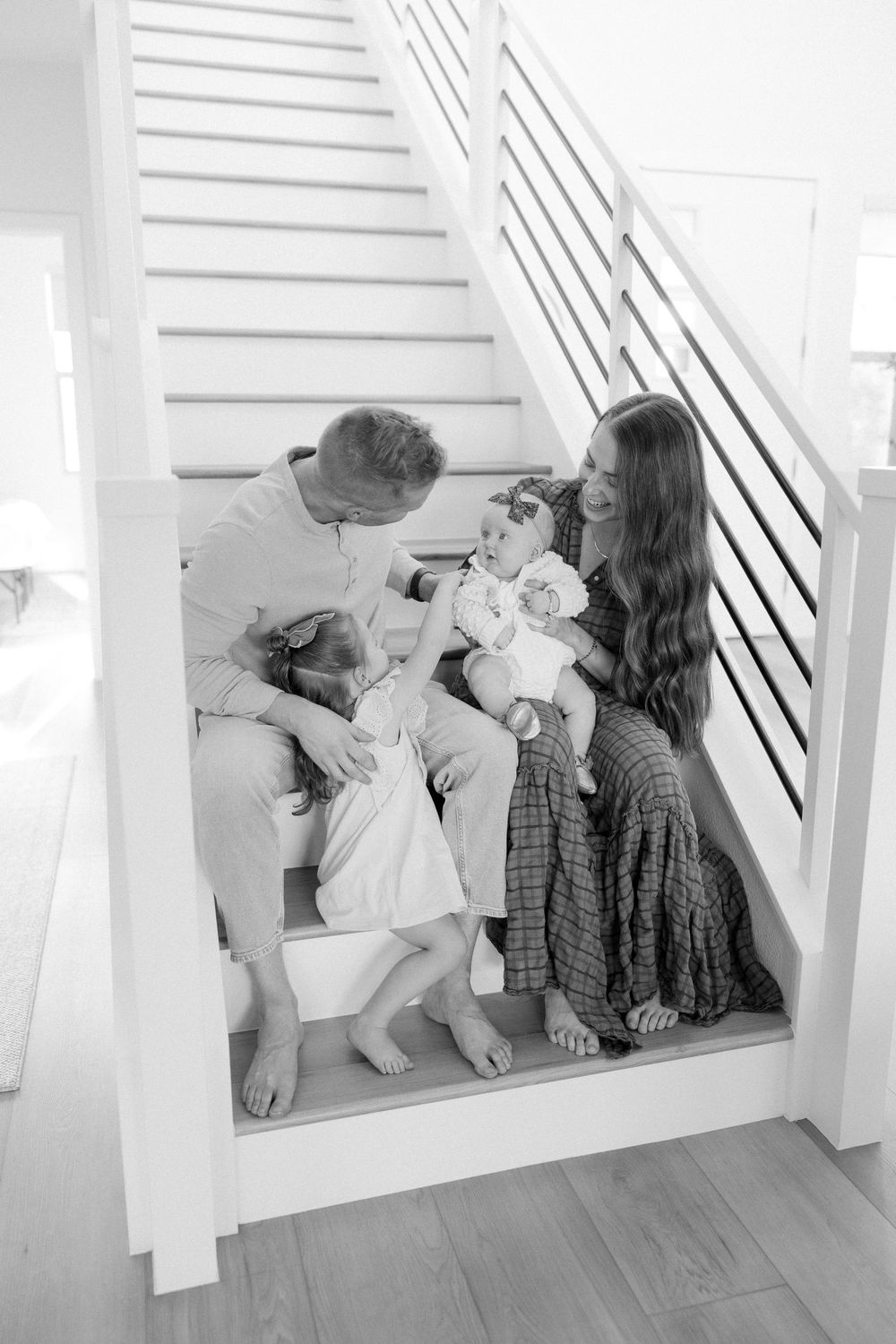 Black and white photo sequence showing a couple sitting in a window nook sharing an intimate moment together.