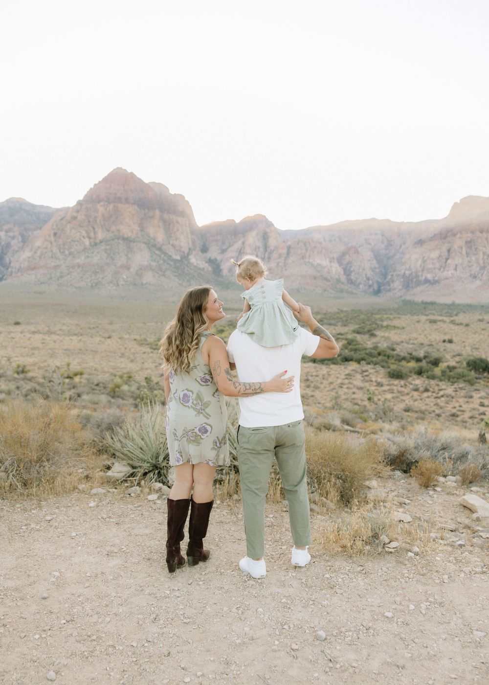 A family enjoys a scenic moment against a backdrop of desert mountains.