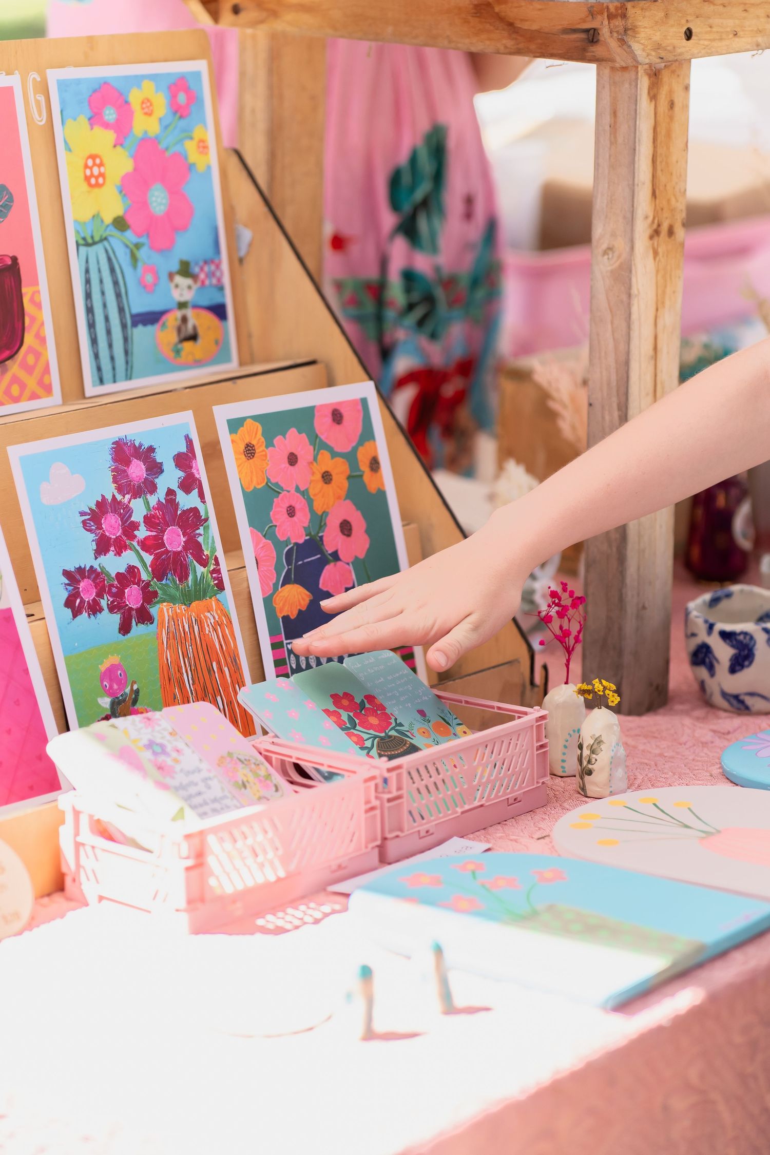 Pastel art prints featuring flowers displayed in a pink organizing tray.