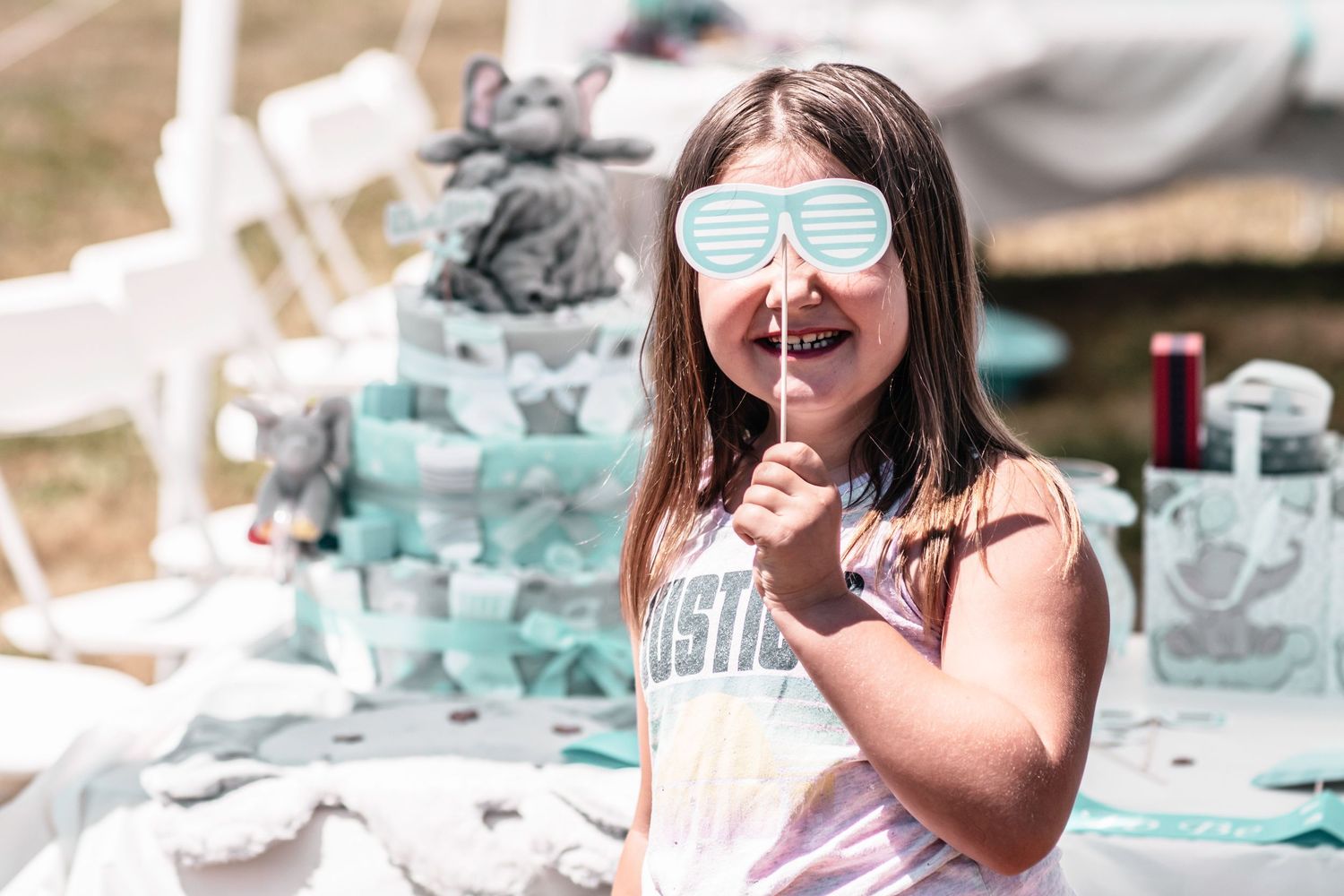 Child holding a paper party prop at a baby shower celebration.