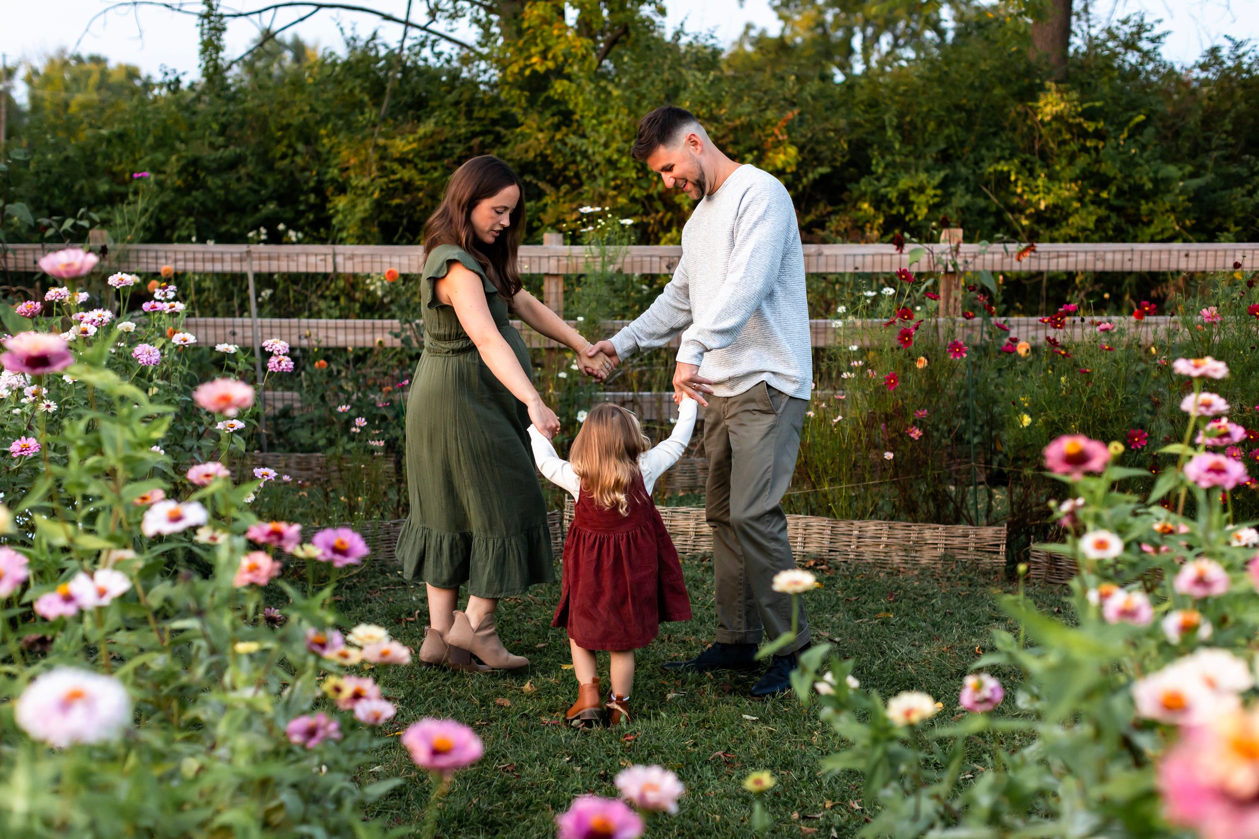 A family shares a tender moment together in a blooming rose garden.