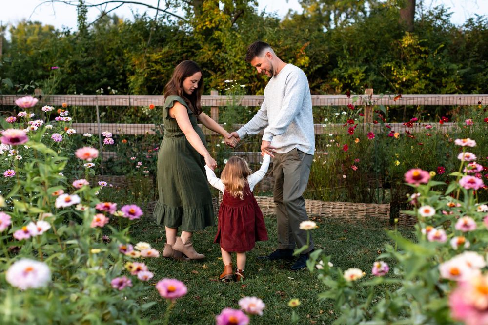 A family shares a tender moment together in a blooming rose garden.