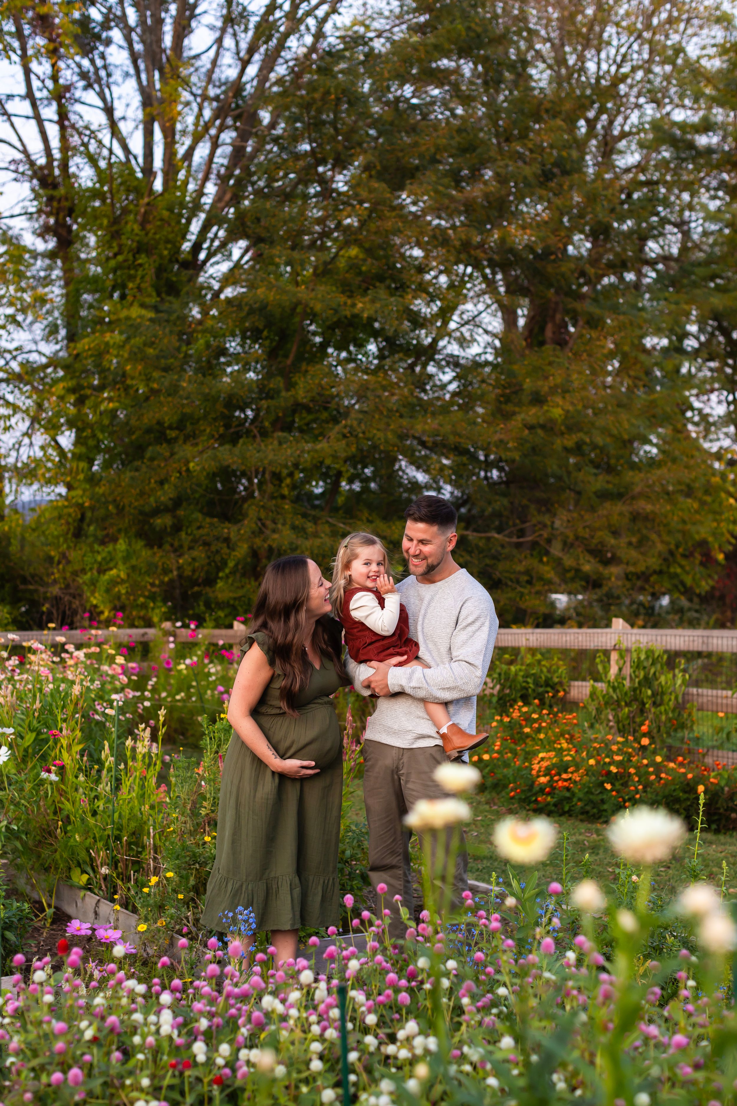 Family sharing joyful moment in flower garden with blooming purple flowers.