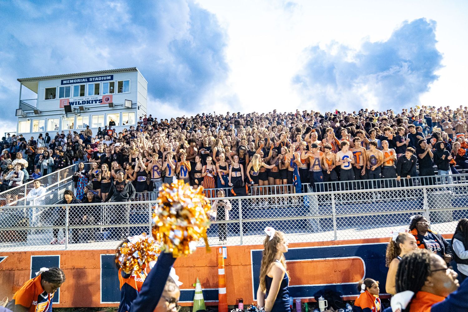 Crowded stadium bleachers filled with enthusiastic fans during a sporting event.