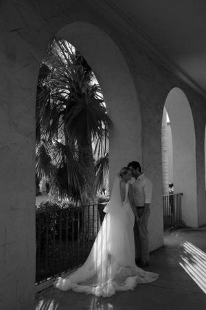 Black and white photo of a couple in an archway with a palm tree silhouette at Balboa Park.