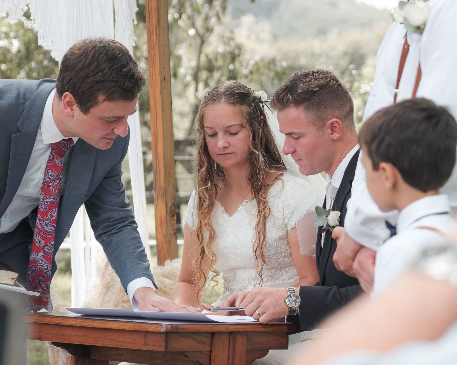 young bride and groom signing contract at the alter in light and airy styled wedding