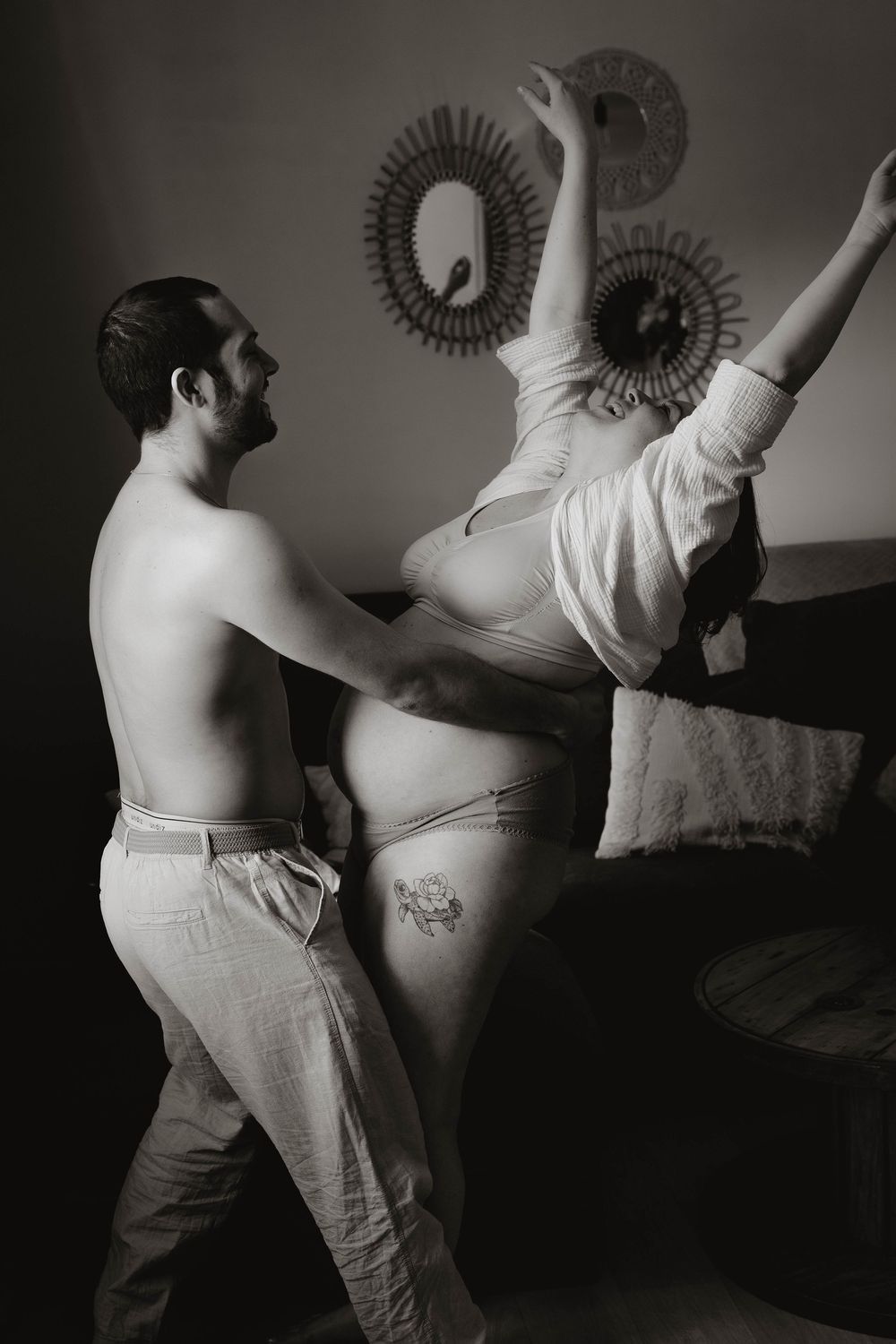 Black and white artistic photo sequence showing dance-like movements against a dark background.