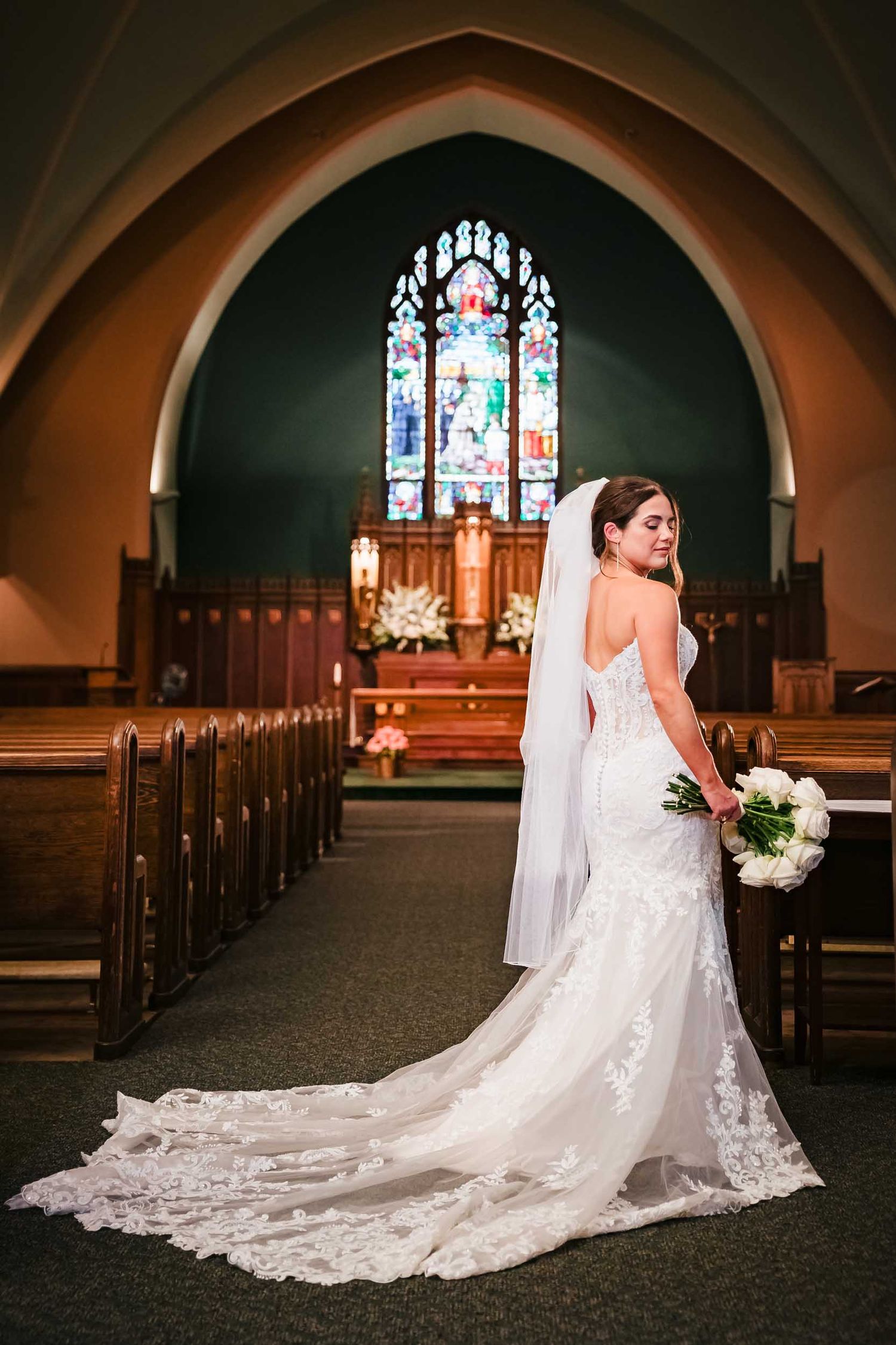 Bride posing in the aisle for a wedding portrait inside Saint Brigid Church in South Boston