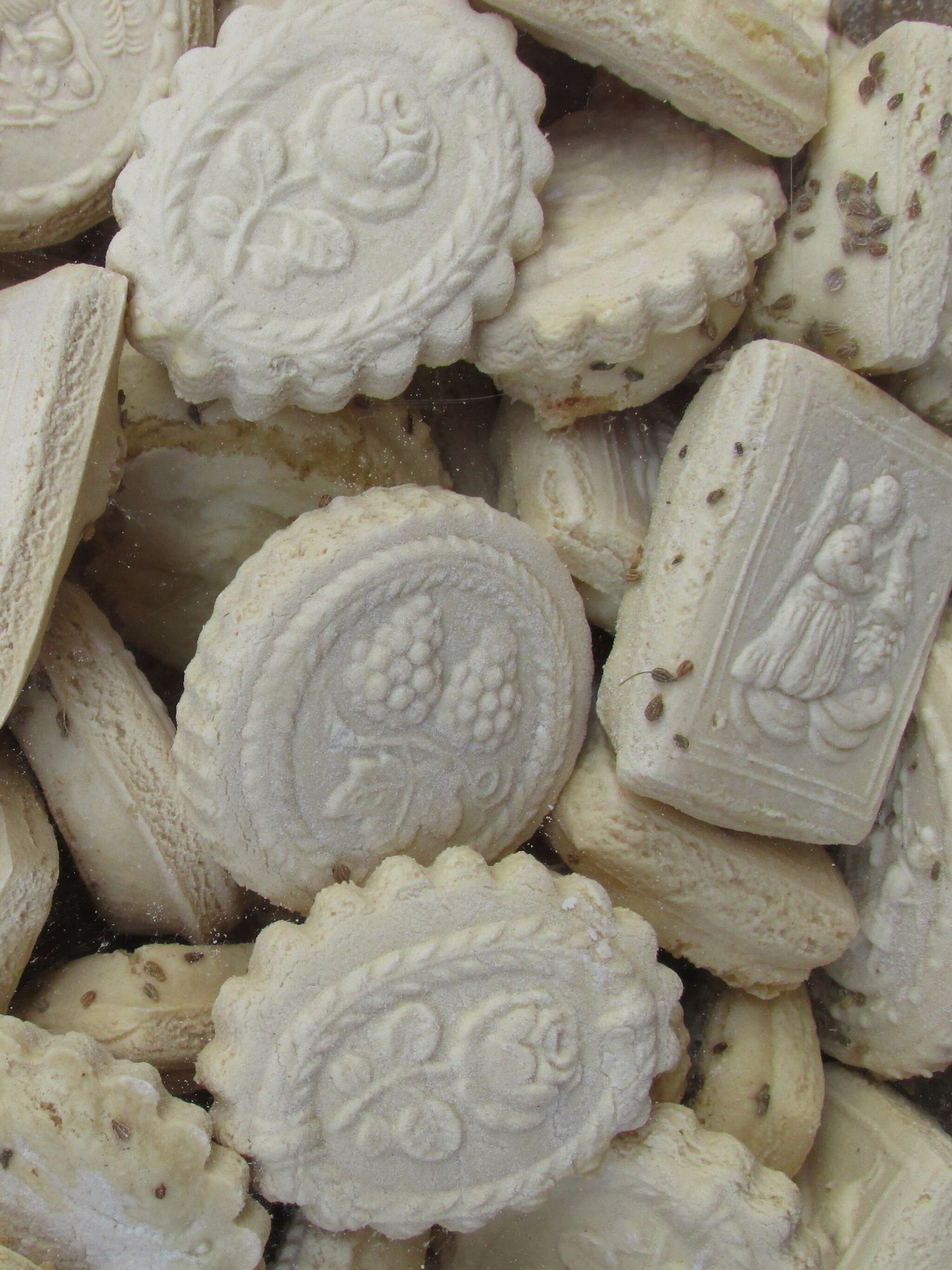 Close-up view of vintage white clay Springerle cookie molds with detailed embossed designs and patterns.