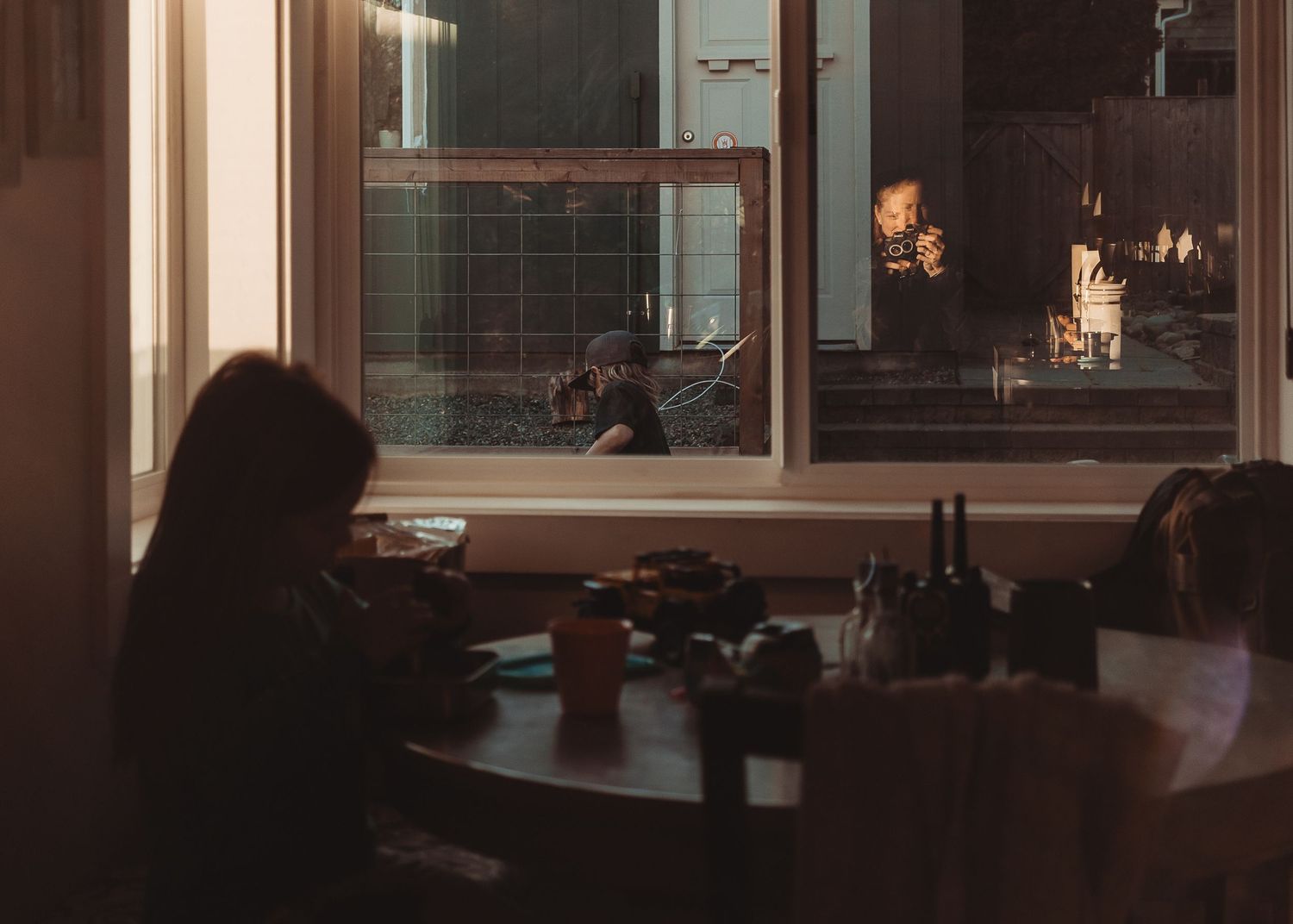 A dimly lit restaurant interior with wooden tables and chairs creates an intimate dining atmosphere at night.