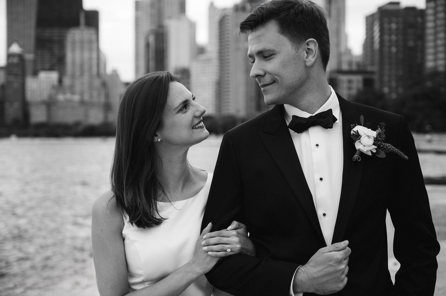 A romantic black and white wedding photo series showing four intimate moments between newlyweds under a flowing veil.