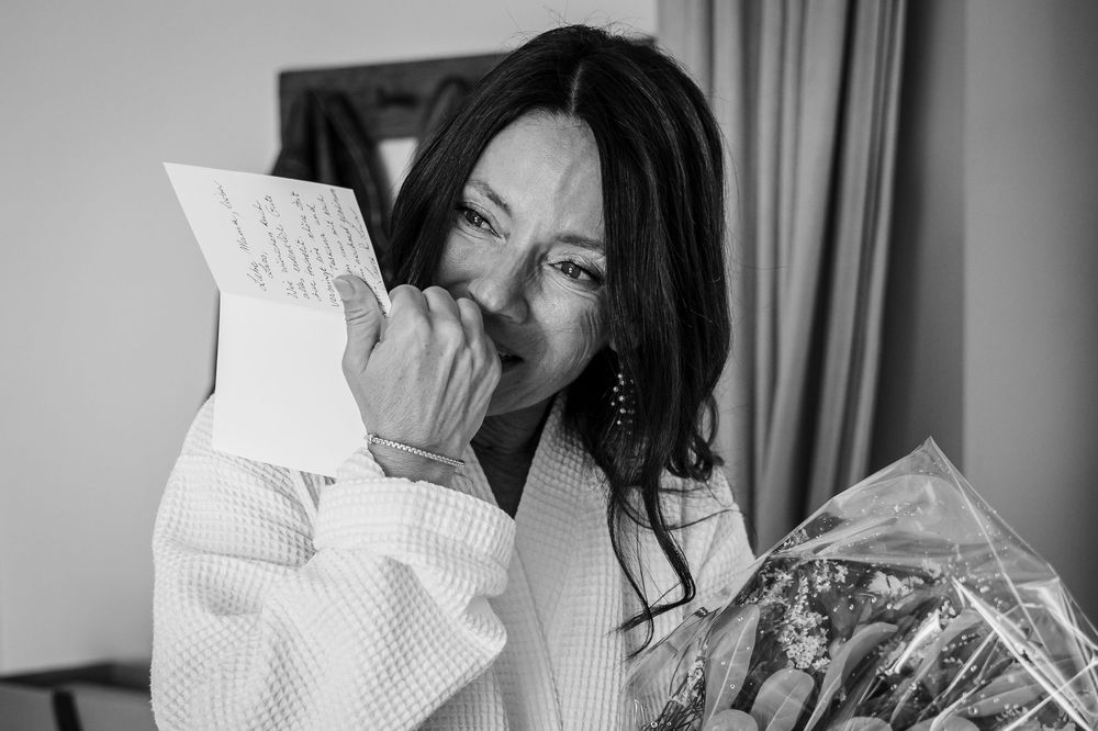 Black and white photo of someone reading a book while sitting in a relaxed position.