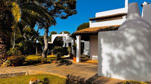 Panoramic view of white Spanish-style architecture with terracotta roofs nestled in a mountainous landscape.