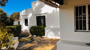 A collage of exterior views showing white stucco walls, windows, and pathways of a Mediterranean-style building complex.