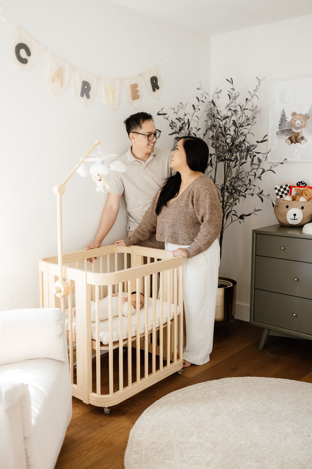 Parents smile at each other in their baby's nursery during their in-home newborn photography session in Sunnyvale