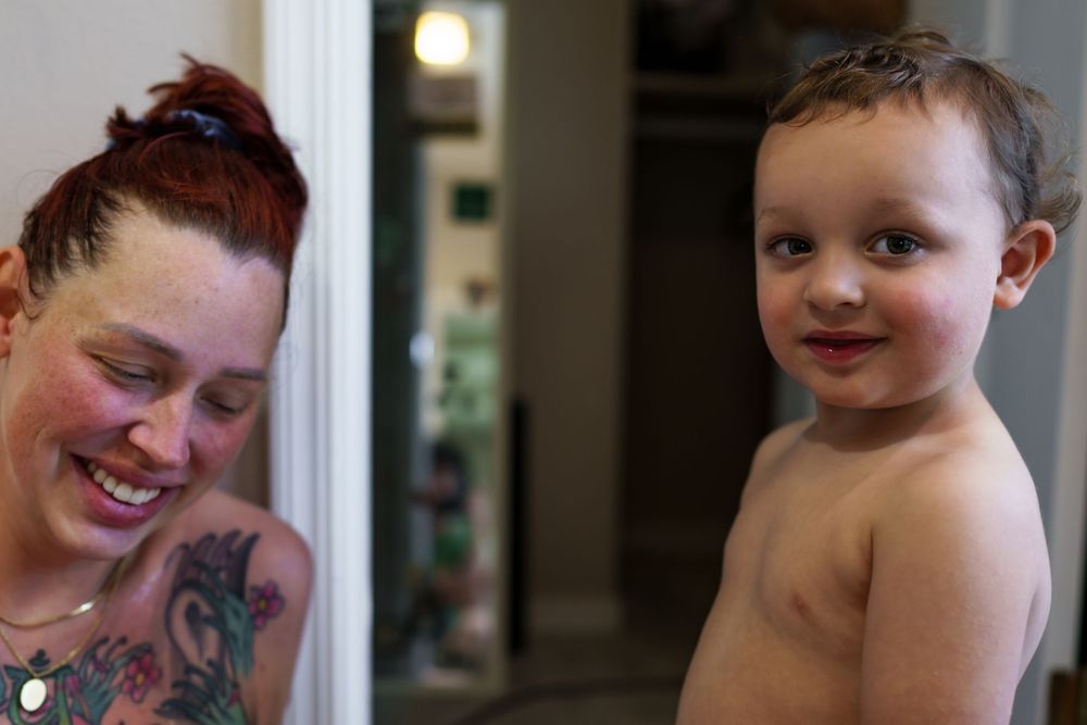 A happy moment shared between parent and child showing colorful tattoo art.