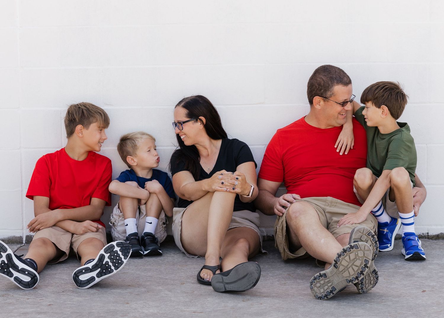 A sequence of five photos showing people sitting against a white wall, arranged in a horizontal layout.