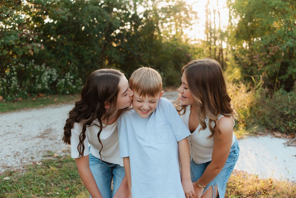Playful family photo session captured in warm evening light.