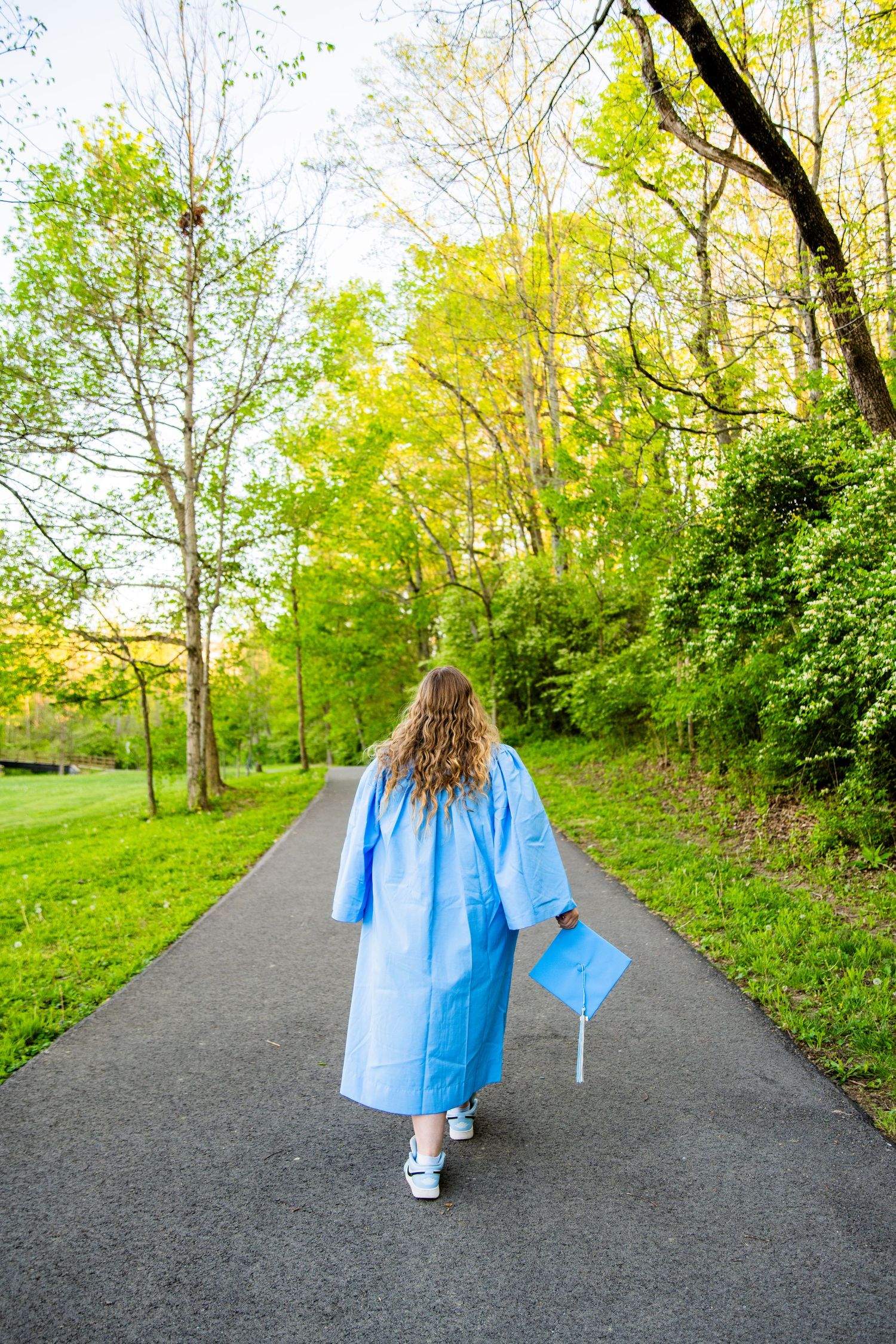 Four graduation photos show a graduate in a black cap and gown smiling warmly against a blurred colorful background.
