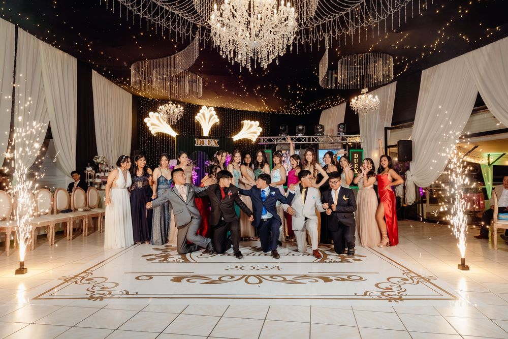 A panoramic view of an elegant wedding reception venue with crystal chandeliers and white decor.