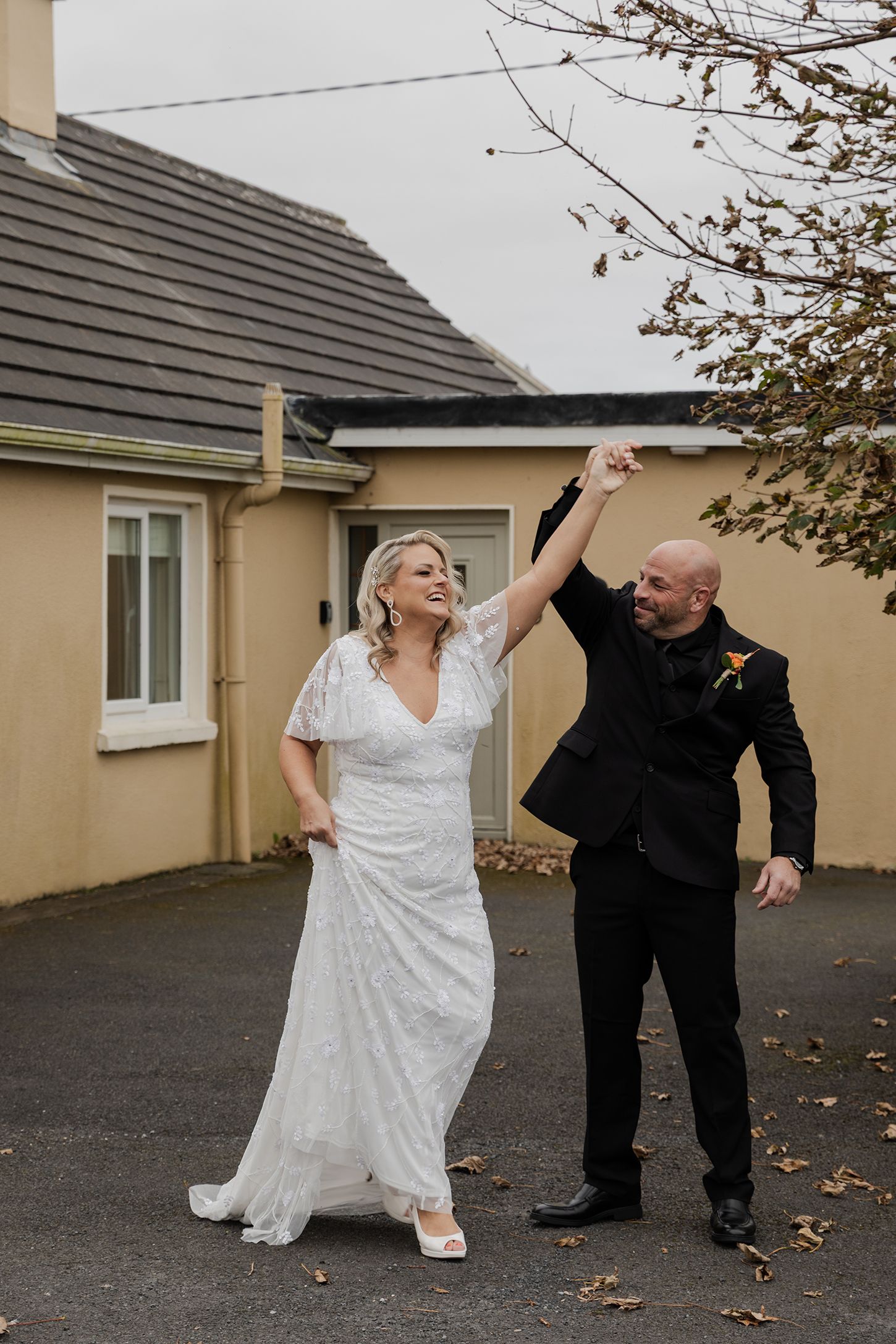 Couple laughing outside cozy Doolin cottage before ceremony.